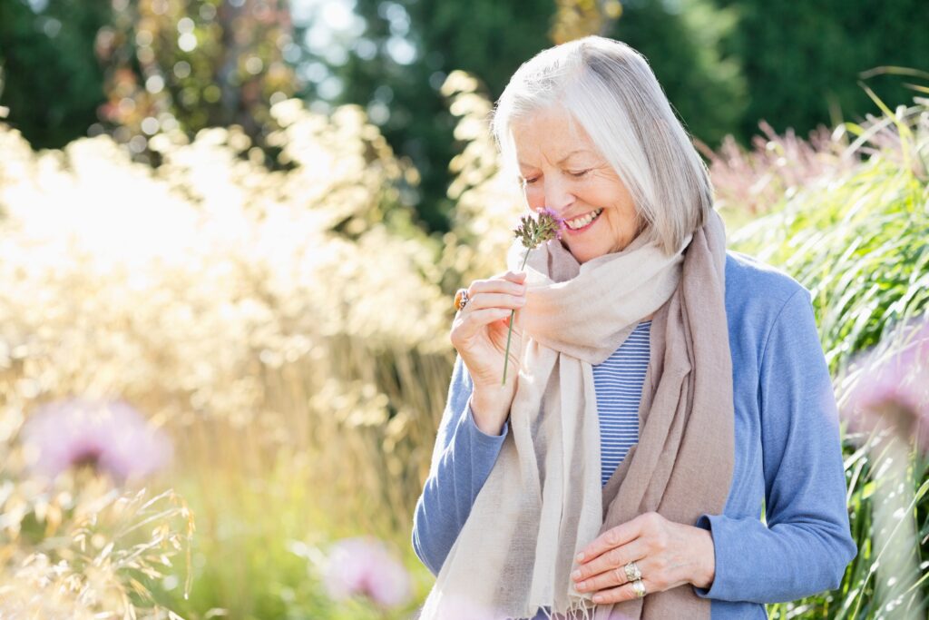 Older,Woman,Smelling,Flowers,Outdoors